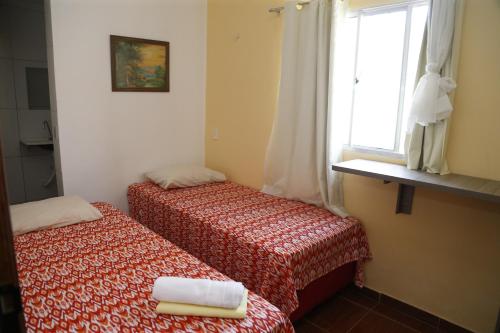 a small room with two beds and a window at The Hotel in Teresina