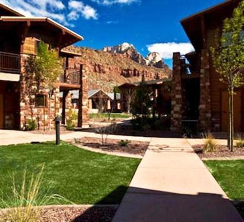 a house with a grass yard and a building at Cable Mountain Lodge in Springdale