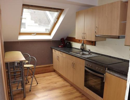 a kitchen with a sink and a stove and a window at Boardinghouse Castell in Bonn