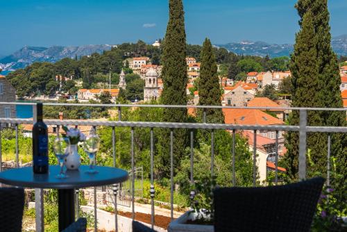 a table with wine glasses on a balcony overlooking a city at Apartments Rilovic, City and Sea view apartments in Cavtat