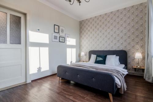 a bedroom with a bed with a blue headboard at APT with sunny garden Prague by Michal&Friends in Prague