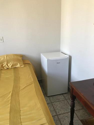 a small refrigerator in a room with a bed at Espaco unico in Sao Jose do Rio Preto
