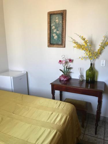 Un dormitorio con una mesa con una cama y flores. en Espaco unico, en São José do Rio Preto