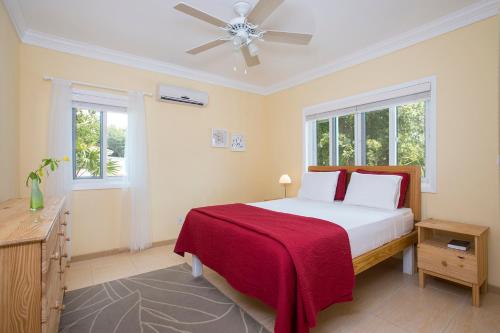 1 dormitorio con 1 cama y ventilador de techo en Sir Charles Guest House, en South Palmetto Point