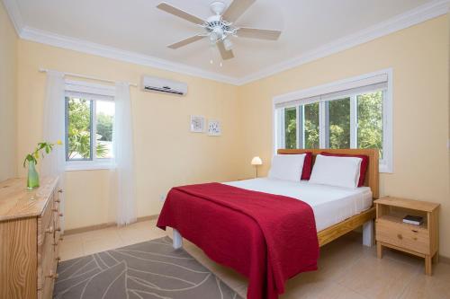 una camera con letto e ventilatore a soffitto di Sir Charles Guest House a South Palmetto Point