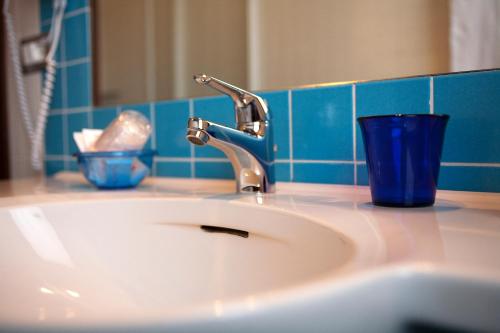 a bathroom sink with a blue glass next to it at Sant'Andrea Agriturismo con cantina Martignago Vignaioli Asolo Prosecco Docg Wines in Maser