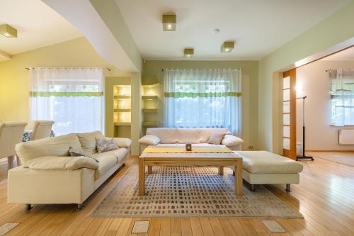 a living room with two couches and a coffee table at Villa EverGreen near the city center with private garden, hot tub, garage parking, patio in Vilnius