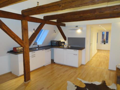 a large kitchen with white cabinets and a wooden floor at New Business Apartment with Flair in Hersbruck