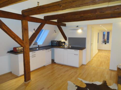 eine große Küche mit weißen Schränken und Holzböden in der Unterkunft New Business Apartment with Flair in Hersbruck