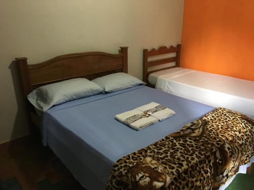 2 camas en una habitación con una cama con estampado de leopardo en Pousada Floresta, en Pirenópolis