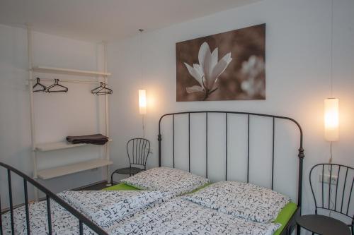 1 dormitorio con 1 cama con 2 sillas y 1 pintura en Apartments "Happy Family", en Rust