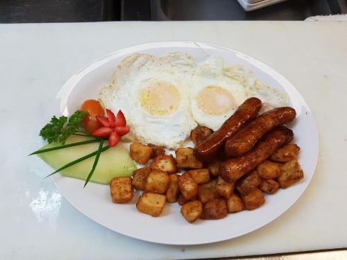 a plate of breakfast food with eggs and potatoes at Coronet Hotel in Prince Albert