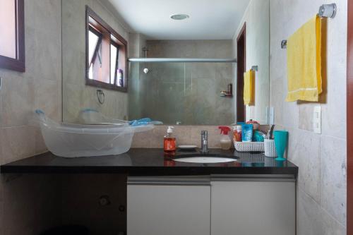 une salle de bain avec un lavabo et une douche dans l'établissement Apartamento no Taiba Beach Resort, à Taíba