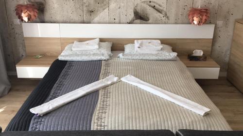 a bedroom with two beds with white towels on them at Hunyadi Apartman in Szekszárd