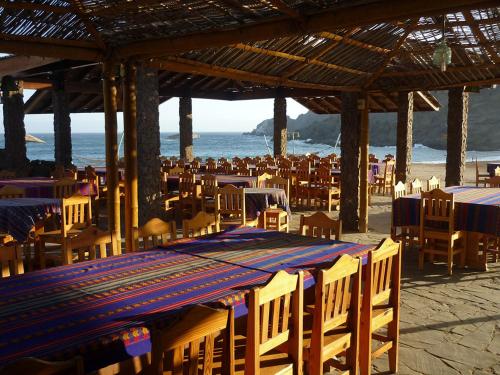 a group of tables and chairs on the beach at Hotel Puerto Inka in Chala