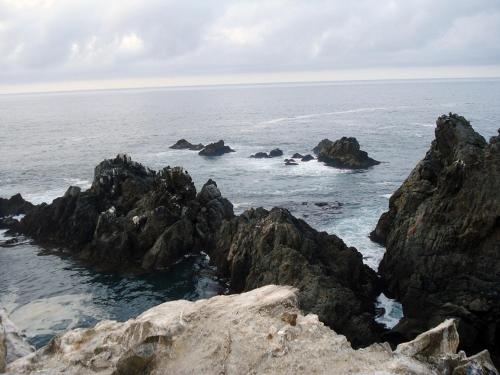 a group of rocks in the ocean near the water at Hotel Puerto Inka in Chala