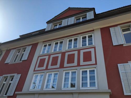 a red and white building with white windows at Villa Jakobsbrunnen in Winterthur