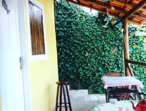 a patio with a table and a green wall at SunriseBelaVista Pousada e Flats in Paraty