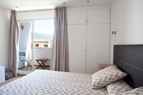 a bedroom with a bed and a large window at Hotel la Vila in Sóller