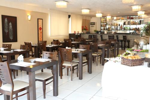a restaurant with wooden tables and chairs and a bar at Al Murjan Palace Hotel Jounieh in Jounieh