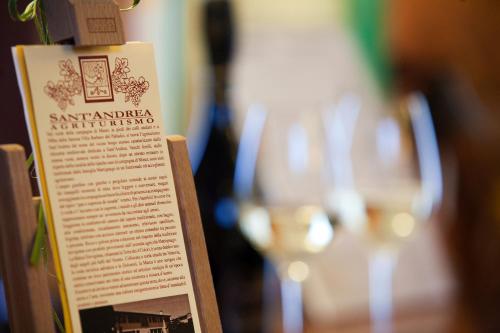 a bottle of wine and glasses on a table at Sant'Andrea Agriturismo con cantina Martignago Vignaioli Asolo Prosecco Docg Wines in Maser