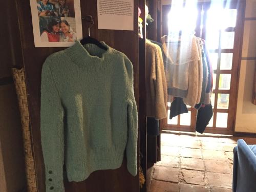 a green sweater on a rack in a room at Hotel Doña Esther in Otavalo