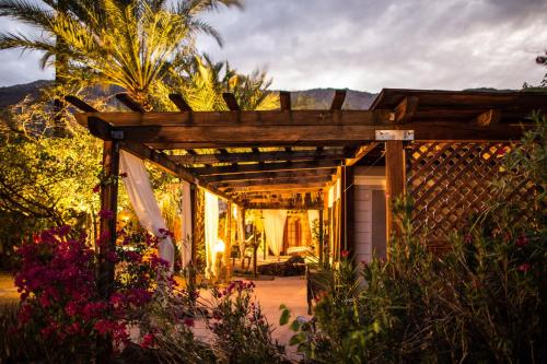 a house with a pergola in a garden at Korakia Pensione in Palm Springs