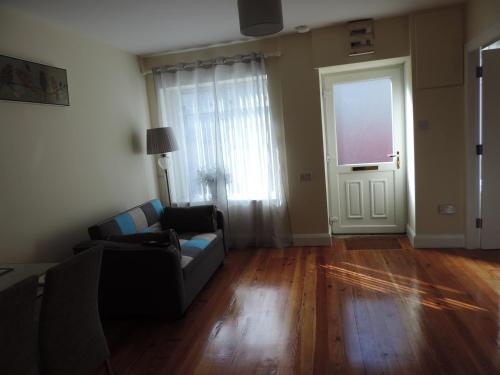 a living room with a couch and a window and a door at 11 Malin Street, Noreens place in Carndonagh