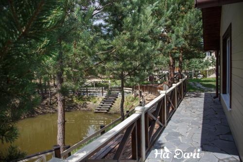 a walkway next to a river with trees at Комплекс На Дачі in Vyshpolʼ