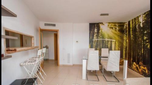 a dining room with a table and a painting on the wall at Apartaments Cambrils Suite Costa Daurada in Cambrils
