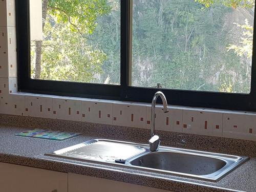 ein Waschbecken in einer Küche mit Fenster in der Unterkunft Cabañas Siete Tazas in Molina