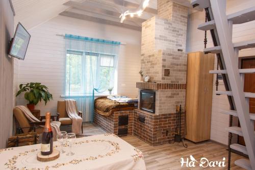 a living room with a fireplace and a bed at Комплекс На Дачі in Vyshpolʼ