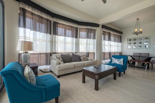 a living room with a couch and chairs and a table at Diamante Beachfront Suites in San Pedro
