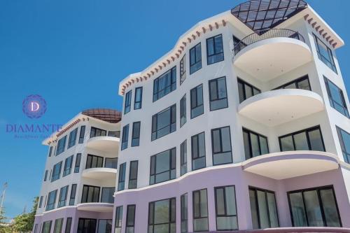 um edifício alto com um céu azul ao fundo em Diamante Beachfront Suites em San Pedro