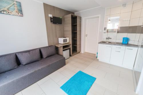 a living room with a couch and a kitchen at Villa Baltic Karwia in Karwia