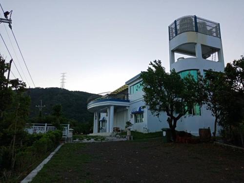 車城鄉的住宿－湯之丘民宿，前面有棵树的白色建筑