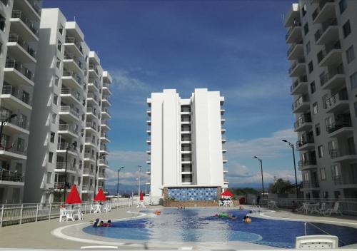dos edificios de apartamentos altos con una piscina frente a ellos en Depto Condominio Aqualina, en Girardot