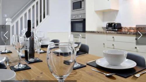 a wooden table with wine glasses on top of it at Swyn y Mor beach close Pet friendly hot tub in Barmouth