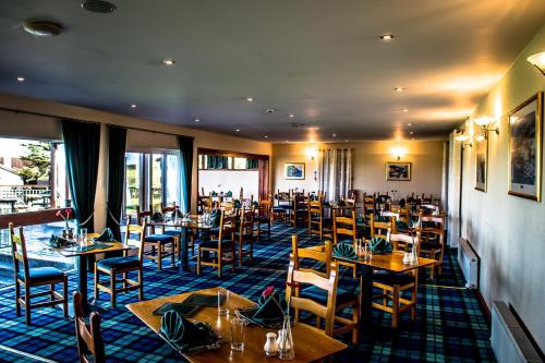 une salle à manger avec des tables et des chaises en bois dans l'établissement Carnegie Lodge Hotel, à Tain