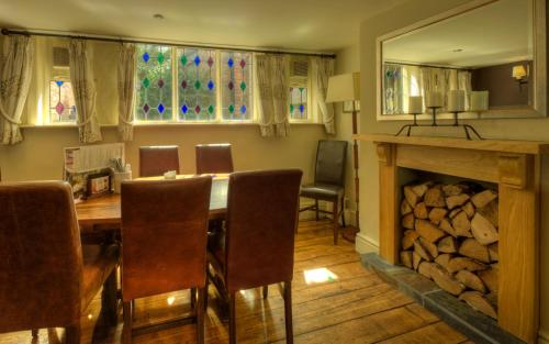 a dining room with a table and a fireplace at Dog & Partridge by Chef & Brewer Collection in Tutbury