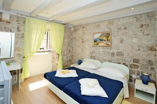 1 dormitorio con cama azul y almohadas blancas en Studio Čikato, en Dubrovnik