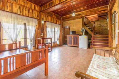 a large living room with wooden walls and wooden ceilings at Rosemary House in Pak Chong