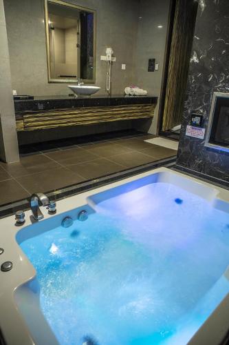 a large blue tub in a bathroom with a sink at One + One Motel in Longtan