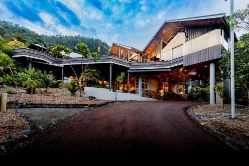 una casa en una colina con entrada en Grand Mercure Puka Park Resort en Pauanui