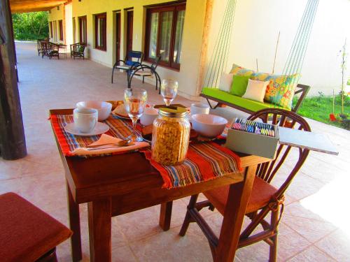 una mesa de madera con comida y copas de vino. en Arandu ecolodge en Colonia Carlos Pellegrini