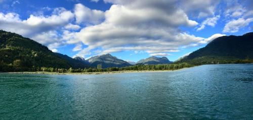 a view of a river with mountains in the background at Cabañas Nutrias Patagonicas in Puelo