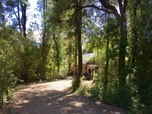 a house in the middle of a dirt road at Cabañas Nutrias Patagonicas in Puelo