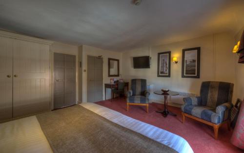 a bedroom with a bed and a chair and a table at Dog & Partridge by Chef & Brewer Collection in Tutbury