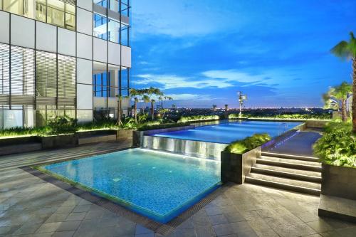a swimming pool on the roof of a building at Novotel Samator Surabaya Timur in Surabaya