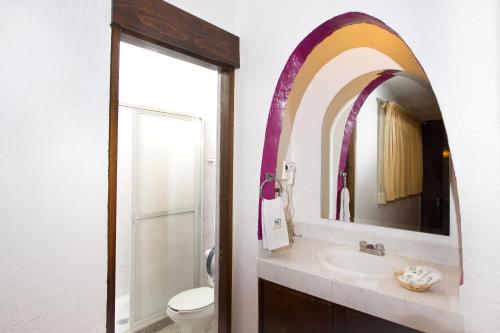 a bathroom with a sink and a mirror at Hotel & Motel Hacienda Jiutepec in Jiutepec
